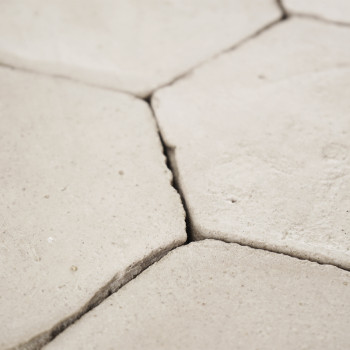 Sechseckige Terrakottafliesen greifen nahtlos ineinander und bilden eine strukturierte Oberfläche, die in einer minimalistischen