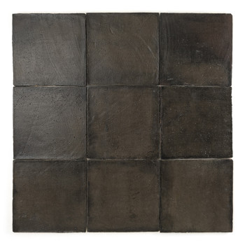 Square terracotta tile rests alone against a plain white background, appearing smooth and dark with subtle texture variations.