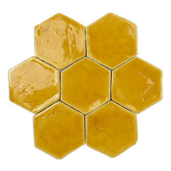 Carreau hexagonal en terre cuite brillante réfléchissant la lumière. placé sur un fond blanc uni.