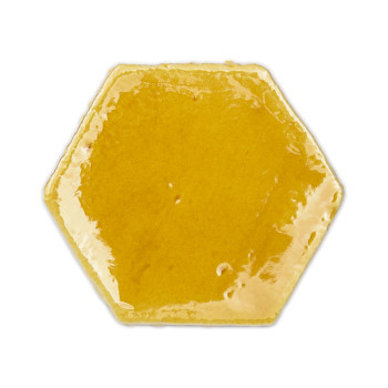 Carreau hexagonal en terre cuite brillante réfléchissant la lumière. placé sur un fond blanc uni.