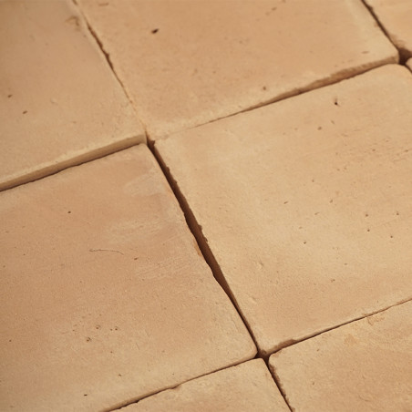Terracotta tiles are arranged in a grid pattern, forming a rustic, warm-toned surface in natural light.