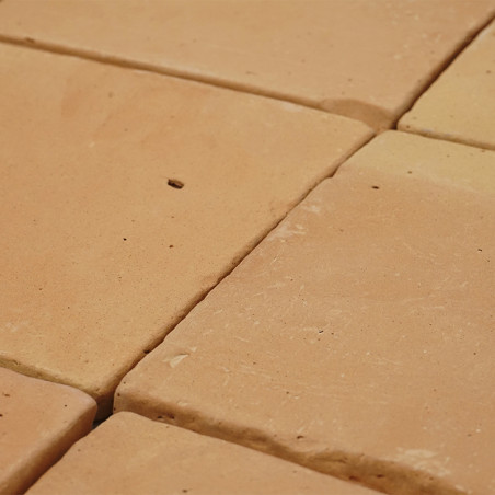 Los azulejos de terracota dispuestas en cuadrícula forman una superficie rugosa y terrosa, con ligeras variaciones de color y te