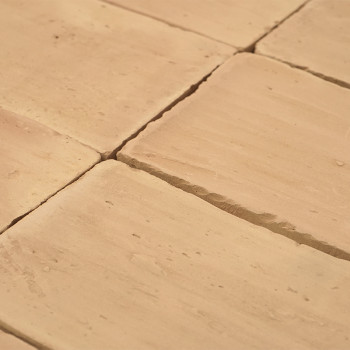 Carreaux en terre cuite posés uniformément, créant une surface lisse et texturée avec des variations subtiles. disposés soigneus