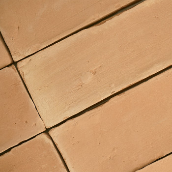 Les carreaux de terre cuite sont plats, formant un motif géométrique, avec une texture légèrement rugueuse et un ton chaud et te