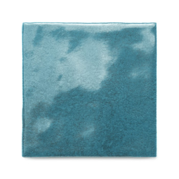 Een vierkante keramische tegel glinstert met een glanzend groenblauw glazuur en reflecteert subtiele lichtvariaties, afgezet teg