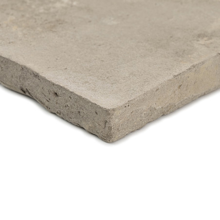 A square terracotta tile rests on a plain, light background, showcasing a rough, matte texture and unfinished edges.