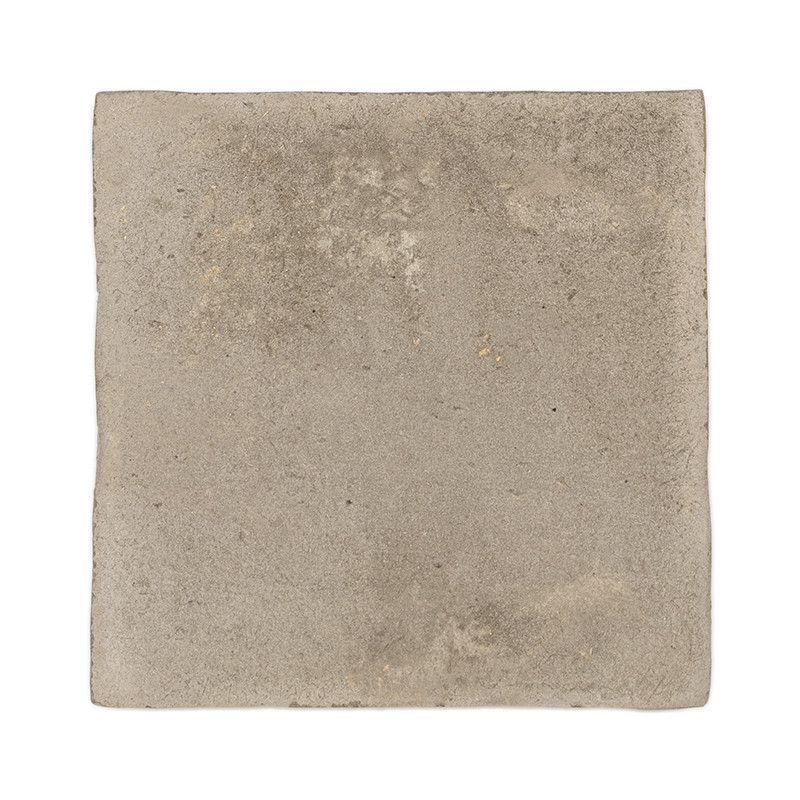 Carreau carré en terre cuite avec une surface rugueuse et texturée et un ton beige sourd, isolé sur un fond blanc.