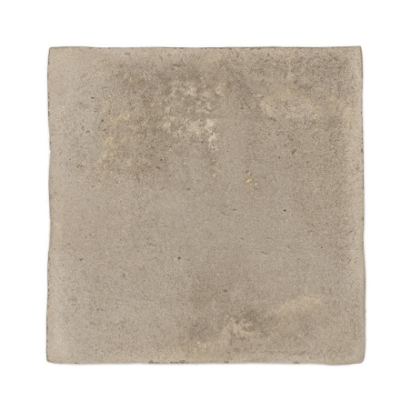 Carreau carré en terre cuite avec une surface rugueuse et texturée et un ton beige sourd, isolé sur un fond blanc.