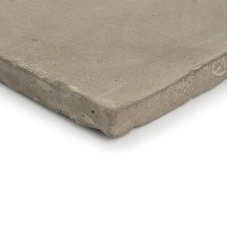 Carreau carré en terre cuite posé à plat, présentant une surface rugueuse, non émaillée et des bords irréguliers. le fond est bl