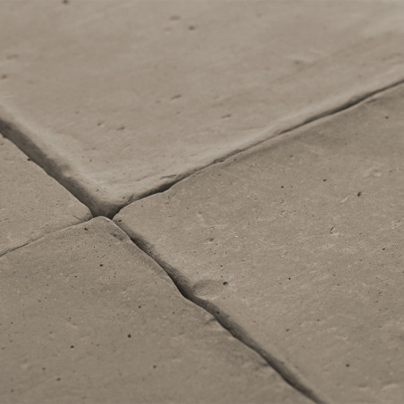 Les carreaux de terre cuite sont étroitement disposés, formant une surface texturée en forme de grille, créant un décor de sol r