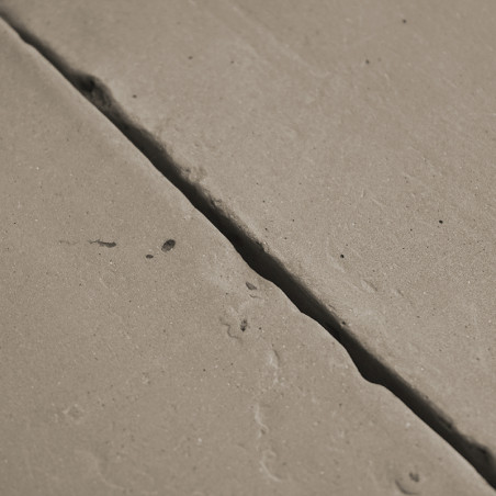 Les carreaux de terre cuite sont inégalement placés, présentant des fissures visibles et une texture légèrement rugueuse dans un