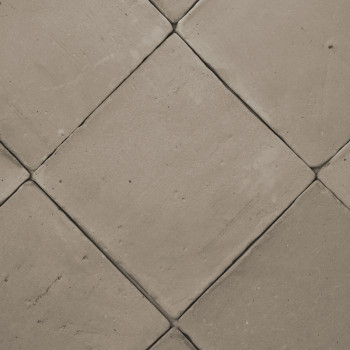 Carreaux de terre cuite disposés en diagonale, créant un motif en losange sur un sol plat de couleur neutre.