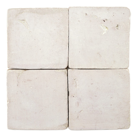 Four square terracotta tiles resting together, displaying subtle texture variations, against a plain white background.