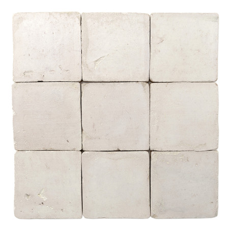 Nine square terracotta tiles are arranged in a 3x3 grid, displaying a rough, off-white surface texture.