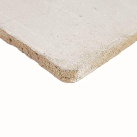 A rough, light beige terracotta tile sits angled, revealing a textured, matte surface and slightly uneven edges.