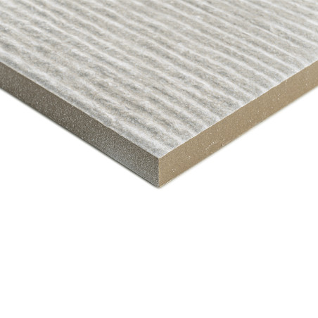 Un carreau rectangulaire texturé présente un motif de surface rayé, reposant à plat sur un fond blanc uni, soulignant son bord e