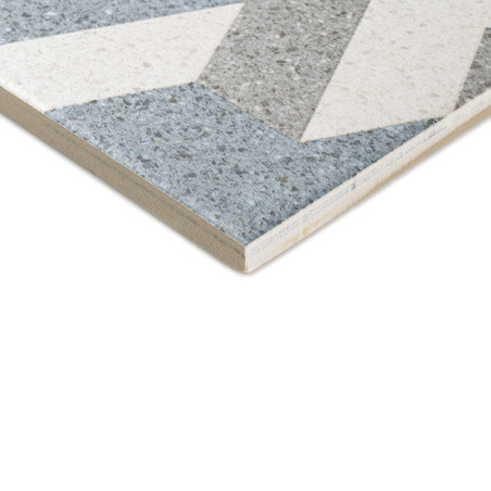 Un carreau de céramique présentant des motifs géométriques avec des sections grises, blanches et bleues. le bord incliné des car