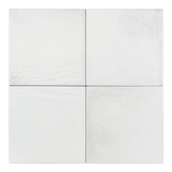 Un azulejo de cerámica blanca y brillante se apoya sobre un fondo liso, mostrando su textura suave y su forma cuadrada.