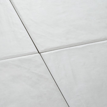 Vier witte keramische tegels vormen een naadloos vierkant patroon en creëren een glad, schoon oppervlak in een minimalistische e