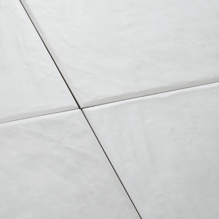 Vier witte keramische tegels vormen een naadloos vierkant patroon en creëren een glad, schoon oppervlak in een minimalistische e