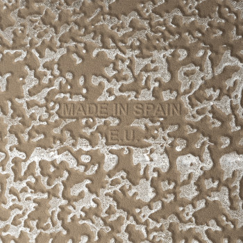 Les textes en relief « MADE IN SPAIN » et « R.E.U. » apparaissent sur une surface texturée et mouchetée avec des motifs blancs i