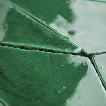 Les carreaux de terre cuite verte, brillants et réfléchissants, s'emboîtent étroitement, créant un motif géométrique sans coutur