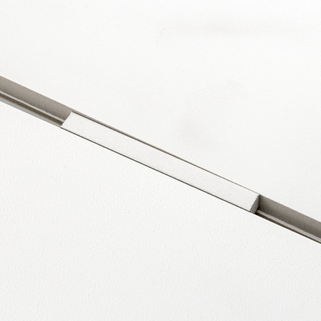 Een witte tegel met een smalle, verzonken rechthoekige groef die hem diagonaal doorsnijdt, waardoor een strakke, minimalistische