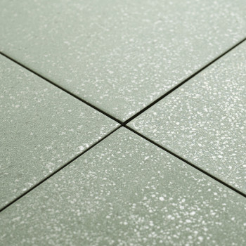 Quatre carreaux carrés verts avec des motifs mouchetés de blanc se croisent au centre, formant une forme de croix. ils sont posé