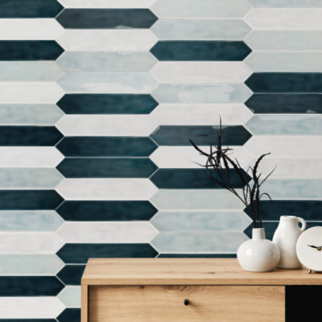 Wooden console with pottery sits before a wall of elongated hexagonal tiles in varying blue and white shades, suggesting a moder