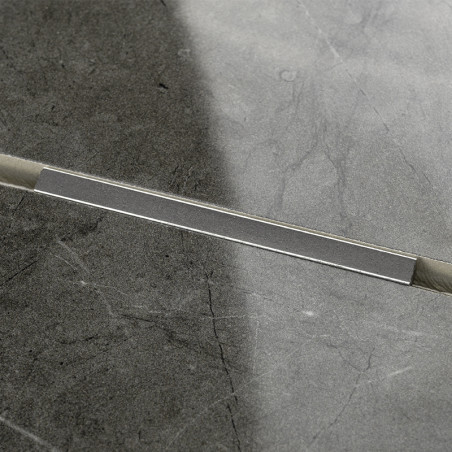 A rectangular gray tile, bisected diagonally, shows a seam with varying shades of gray. The surface displays a subtle marbled te