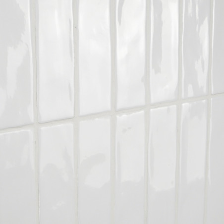 Les carreaux rectangulaires blancs brillants reflètent la lumière, donnant une impression de propreté et de simplicité dans un a