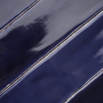 Los azulejos azul marino ondulados y brillantes alineados en diagonal crean una superficie lisa y reflectante con sutiles variac