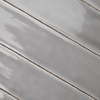 Los azulejos de cerámica gris están dispuestas en diagonal, reflejando la luz con un acabado brillante, alineadas estrechamente 