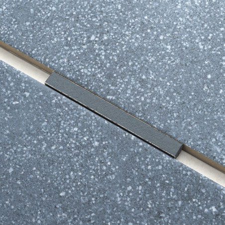 Un carreau gris moucheté croise au niveau d'un joint un autre carreau identique, étroitement bordé par une fine bande contrastée