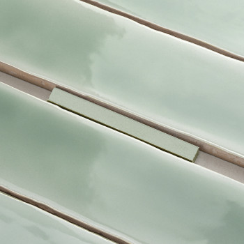 De longs carreaux verts brillants alignés en rangées parallèles, créant une surface lisse et réfléchissante avec des lignes de c