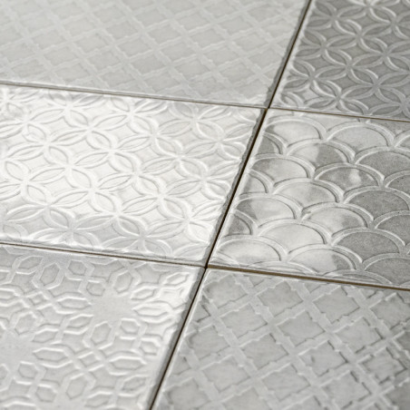 Les carreaux carrés aux motifs géométriques en relief s'emboîtent parfaitement, mettant en valeur des motifs circulaires qui se 