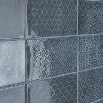 Nove ladrilhos quadrados com padrões geométricos texturizados, incluindo desenhos de diamante, circulares e vieiras, dispostos e