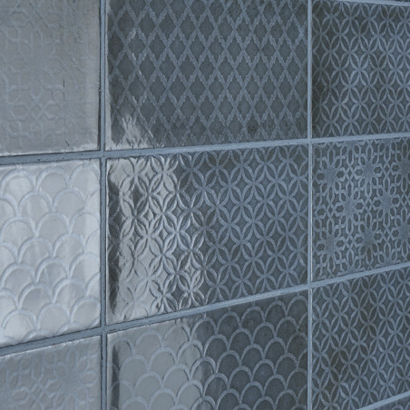 Neuf carreaux carrés avec des motifs géométriques texturés, notamment des motifs en losange, circulaires et festonnés, disposés 