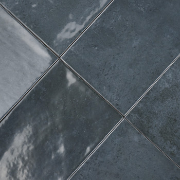Los azulejos de cerámica de color gris oscuro están alineados en diagonal, reflejando la luz sutilmente a través de sus superfic
