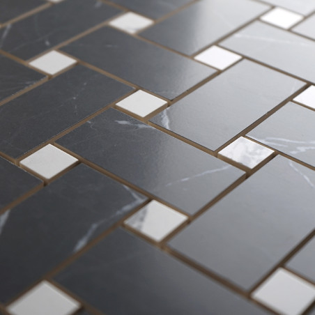 Les carreaux gris rectangulaires sont disposés selon un motif à chevrons, entrecoupés de petits carreaux carrés blancs, créant u