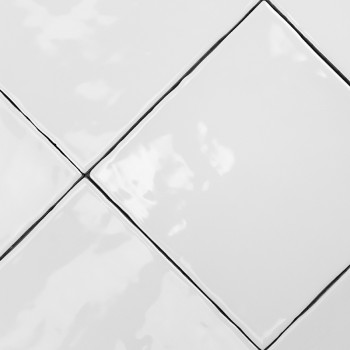 Weiße Keramikfliesen bilden ein diagonales Muster mit glatten Oberflächen, die das Licht reflektieren, eingerahmt von dünnen sch