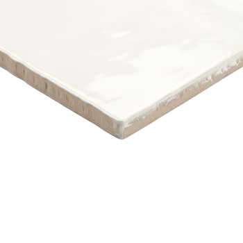 A square ceramic tile displays a glossy, white finish with slightly rough beige edges, resting on a plain white background.