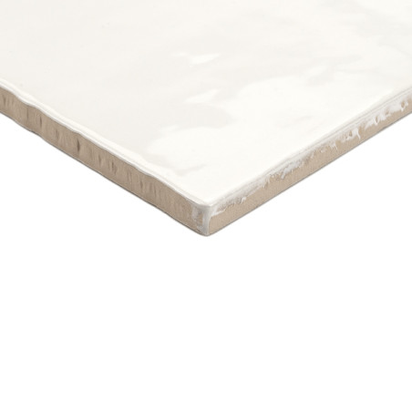 A square ceramic tile displays a glossy, white finish with slightly rough beige edges, resting on a plain white background.
