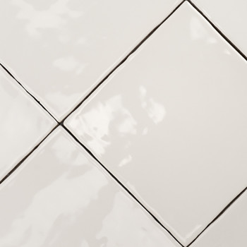 Glossy white square tiles are arranged in a diagonal pattern, creating a smooth, reflective surface with visible grout lines in 