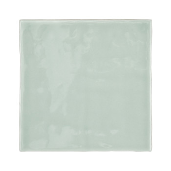 Un azulejo cuadrado liso, brillante y de color verde pálido refleja la luz sutilmente y muestra una estética minimalista y moder