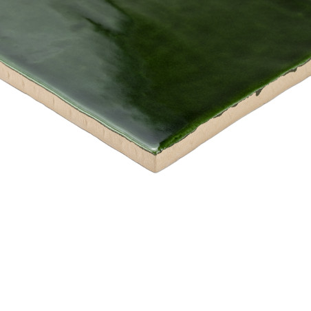 Se muestra Un azulejo cerámico verde oscuro brillante con una superficie lisa y bordes beige, sobre un fondo blanco liso.