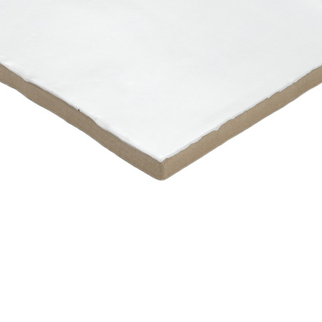 Un azulejo de cerámica cuadrado blanco con bordes lisos descansa sobre un fondo liso de color marrón claro, mostrando su diseño 