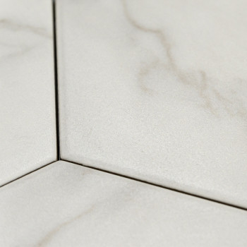 Les carreaux hexagonaux présentent de subtils motifs marbrés gris clair, disposés étroitement ensemble, formant une surface liss