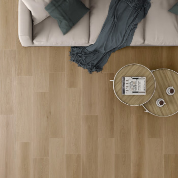 Un canapé beige avec des coussins bleu sarcelle se trouve à côté d'une table basse en bois sur un parquet en bois clair, créant 