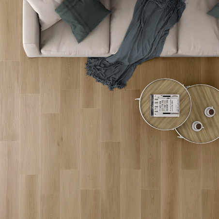 Un canapé beige avec des coussins bleu sarcelle se trouve à côté d'une table basse en bois sur un parquet en bois clair, créant 